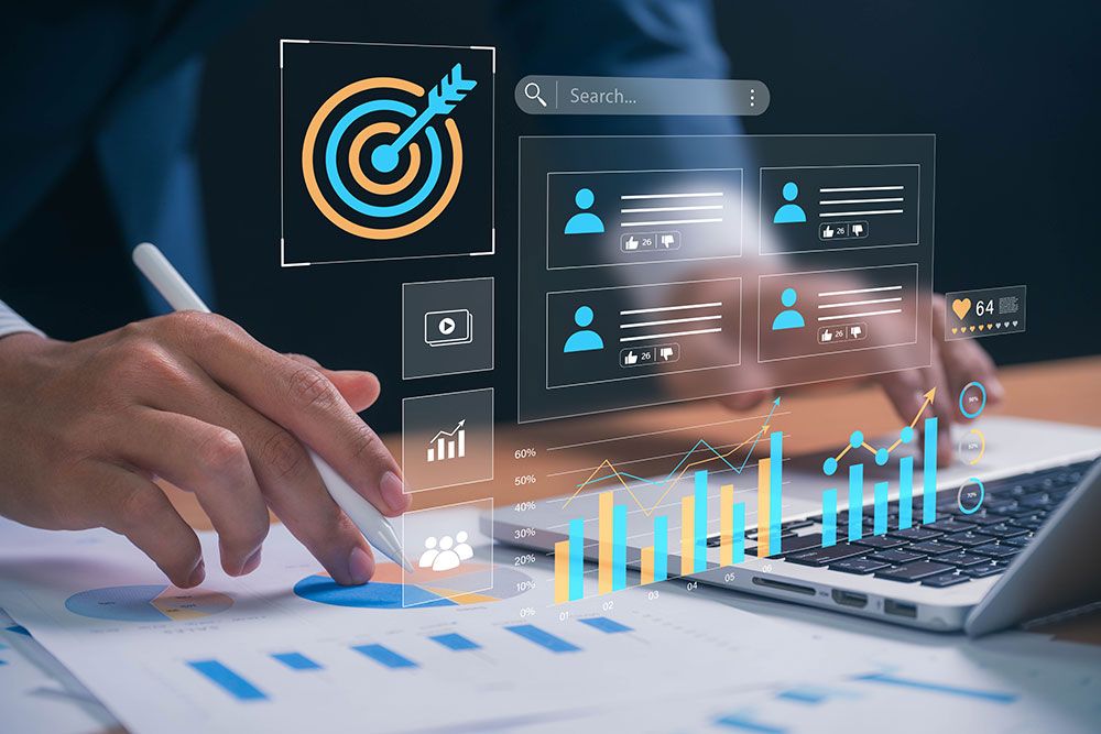 Person using a laptop for marketing analytics, featuring data graphs and a target icon.