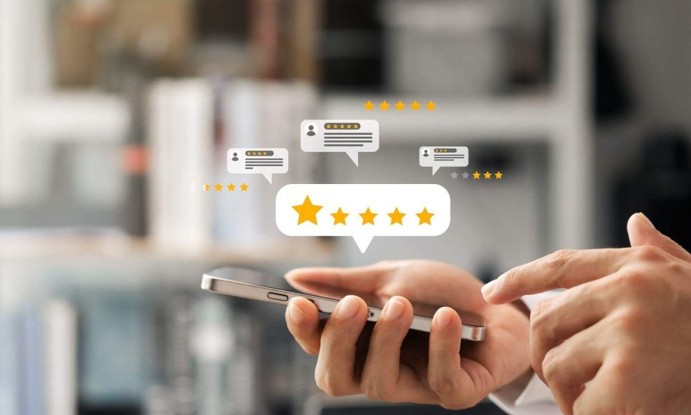 a person using a cell phone in what appears to be a review for a business, 5 stars are shown