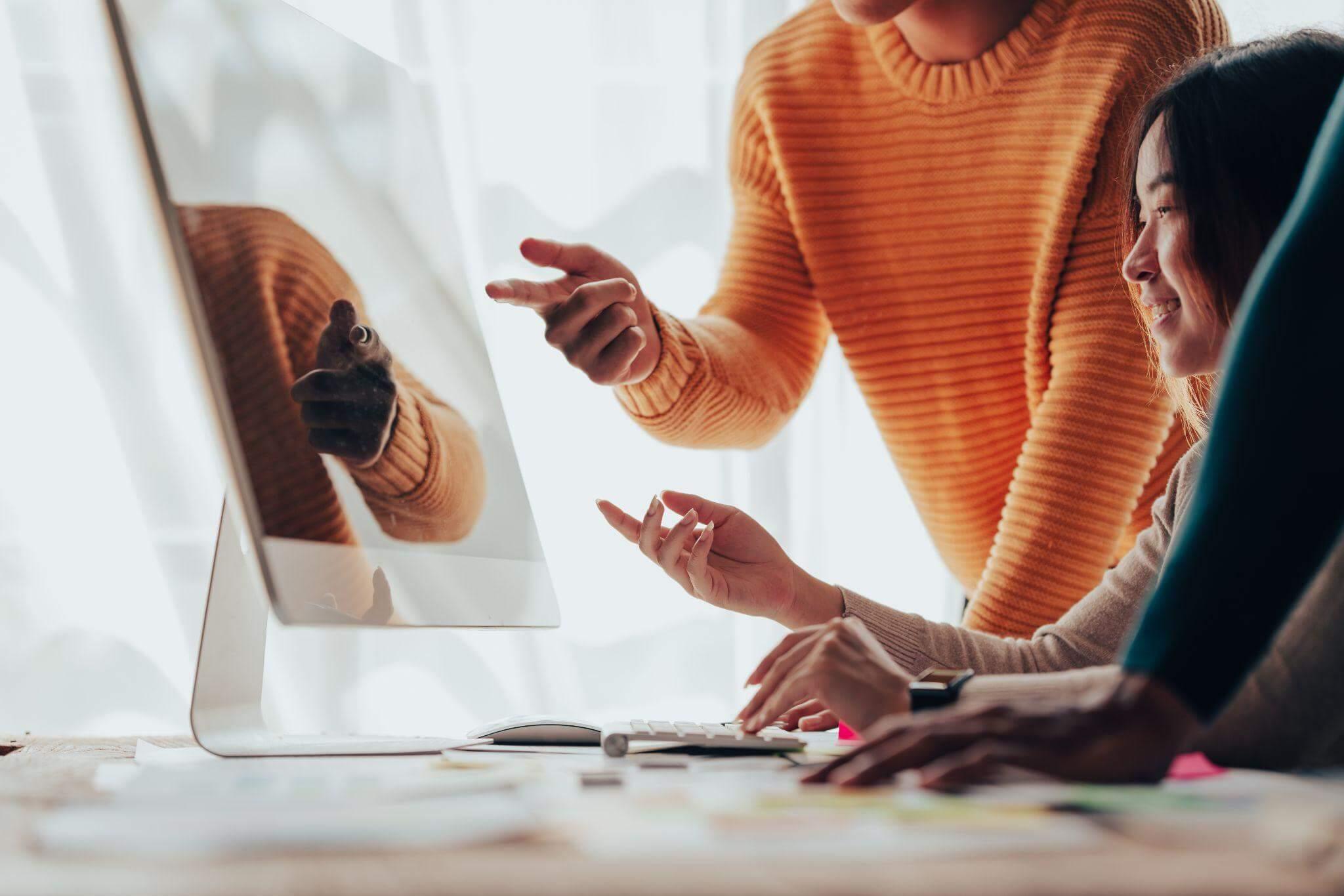 Two women collaborating on content review at a
